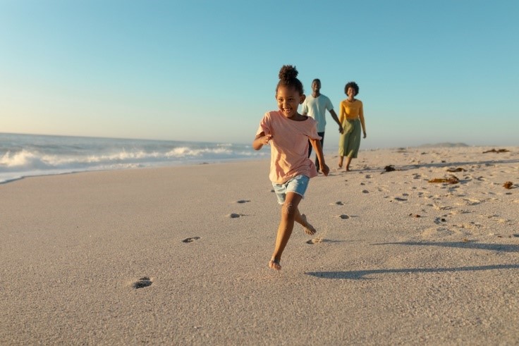 little girl running on beach during the day