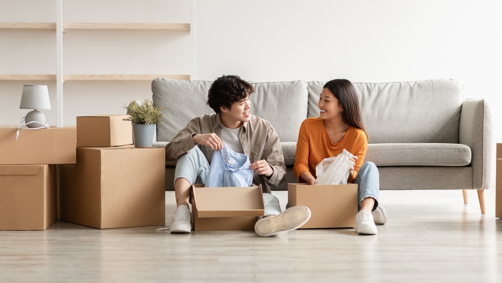 Couple sitting on floor and packing boxes