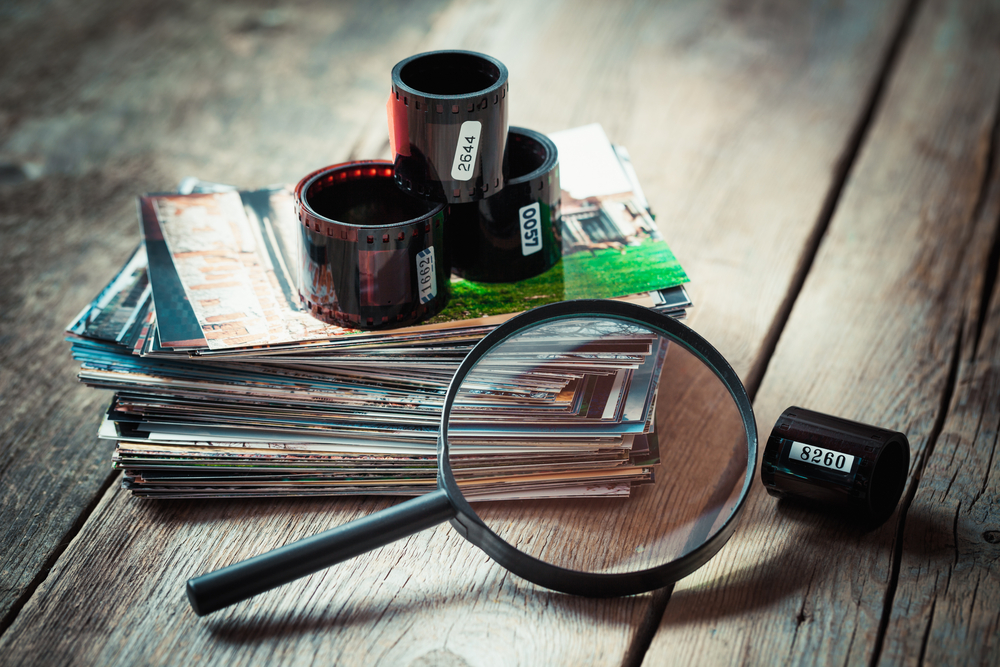 Photos and film on a table with a magnifying glass